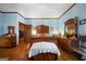 Comfortable bedroom with blue walls, hardwood floors, and classic wooden furniture at 680 Milligan Creek Rd, Roopville, GA 30170