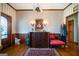 Cozy entryway features hardwood floors, patterned wallpaper, and antique furniture with decorative lighting fixtures at 680 Milligan Creek Rd, Roopville, GA 30170
