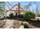 Charming exterior of a home with a red roof, complemented by a stone walkway and lush landscaping at 680 Milligan Creek Rd, Roopville, GA 30170