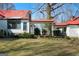 Charming home exterior featuring a covered walkway connecting different sections of the house, enhanced by green lawns at 680 Milligan Creek Rd, Roopville, GA 30170