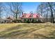 Charming two-story home featuring a red metal roof, dormer windows, and a spacious front yard at 680 Milligan Creek Rd, Roopville, GA 30170