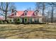 Charming two-story home featuring a red metal roof, dormer windows, and a spacious front yard at 680 Milligan Creek Rd, Roopville, GA 30170