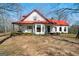 Quaint home exterior with a red roof, offering a cozy and inviting atmosphere, surrounded by nature at 680 Milligan Creek Rd, Roopville, GA 30170