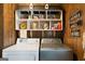 Cozy laundry room features wood walls, a shelf with a house-like structure, and modern washer and dryer at 680 Milligan Creek Rd, Roopville, GA 30170