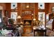 Cozy living room featuring brick fireplace, wood-paneled walls, comfortable seating, and hardwood flooring at 680 Milligan Creek Rd, Roopville, GA 30170