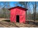Rustic red outbuilding with a weathered appearance, adding character to the outdoor space of the property at 680 Milligan Creek Rd, Roopville, GA 30170