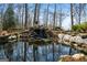 Pond with a rock waterfall, creating a peaceful and serene water feature at 680 Milligan Creek Rd, Roopville, GA 30170