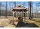 Picturesque well with a decorative roof, adding rustic charm to the wooded landscape at 680 Milligan Creek Rd, Roopville, GA 30170
