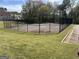 Outdoor tennis court surrounded by lush greenery and a black fence at 122 Lake Ter, Mcdonough, GA 30253