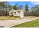 Spacious home featuring a long driveway and an attached two-car garage surrounded by mature trees at 370 Burton Dr, Douglasville, GA 30134