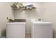 Functional laundry room features a washer, dryer, and overhead storage shelf at 370 Burton Dr, Douglasville, GA 30134