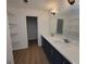 Bathroom featuring a double sink vanity with modern fixtures and ample storage, plus wire rack shelving at 1433 Butler St, Jonesboro, GA 30236