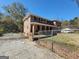 Side view of a beautiful brick house featuring a gated entrance and mature trees at 1433 Butler St, Jonesboro, GA 30236
