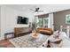Cozy living room featuring stylish furniture, a ceiling fan, a large flat-screen TV, and large windows at 2581 Astaire Ct, Atlanta, GA 30318