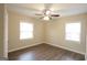 This bedroom offers a ceiling fan, wood-look flooring, and two windows for natural light at 4242 Timber Valley Ct, Decatur, GA 30032
