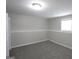 An empty bedroom with gray carpet, one window, and gray walls, ready for personalization at 1897 Madras Ct, Lithonia, GA 30058
