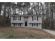 Charming two-story home with dark roof and black shutters nestled among trees at 1897 Madras Ct, Lithonia, GA 30058
