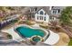 Aerial view of a backyard featuring a pool with a safety fence, patio, and well-maintained landscaping at 610 Graystone Ct, Peachtree City, GA 30269