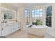 Bright bathroom featuring double sinks, a standalone tub, and natural light at 610 Graystone Ct, Peachtree City, GA 30269