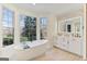 Bright bathroom featuring double sinks, a standalone tub, and natural light at 610 Graystone Ct, Peachtree City, GA 30269