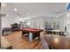 Entertaining game room with pool table, arcade games, and a cozy seating area with hardwood floors at 610 Graystone Ct, Peachtree City, GA 30269