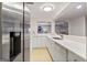 Bright kitchen featuring white cabinetry, stainless steel appliances, and a convenient breakfast bar overlooking a rec room at 610 Graystone Ct, Peachtree City, GA 30269