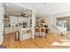 Bright kitchen featuring an island with seating, white cabinets, stainless steel appliances, and hardwood floors at 610 Graystone Ct, Peachtree City, GA 30269