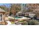 Backyard with a gated pool, spa, covered lounge, and meticulously landscaped garden offers luxury outdoor living at 610 Graystone Ct, Peachtree City, GA 30269