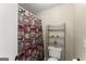 Bathroom featuring a toilet and decorative shelving behind a colorful shower curtain at 402 Mill Pond Rd # 402, Roswell, GA 30076