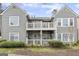 Charming condo featuring double balconies with gray wood siding, white trim, and neatly manicured bushes in the front at 402 Mill Pond Rd # 402, Roswell, GA 30076