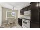 Eat in kitchen with bright window, white appliances and cabinets, tile counters and flooring, and ceiling fan at 402 Mill Pond Rd # 402, Roswell, GA 30076