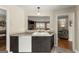 Kitchen with view of living room, featuring dark cabinets, white appliances, tile counters and flooring at 402 Mill Pond Rd # 402, Roswell, GA 30076