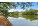 Scenic lake view with reflections of surrounding trees and buildings on a sunny day with a clear blue sky at 402 Mill Pond Rd # 402, Roswell, GA 30076