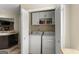 Washer and dryer enclosed in a laundry closet with shelving in the kitchen at 402 Mill Pond Rd # 402, Roswell, GA 30076