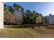 Backyard view of property with expansive lawn space and surrounding trees at 2536 Lancewood Ln, Lithonia, GA 30058