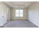 Bedroom featuring a large window, tray ceiling, and light colored carpet at 2536 Lancewood Ln, Lithonia, GA 30058