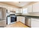 Well-lit kitchen with stainless steel fridge and dishwasher, gas range, and generous white cabinets at 2536 Lancewood Ln, Lithonia, GA 30058