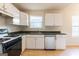 Bright kitchen featuring stainless steel dishwasher, white cabinets, and green countertops at 2536 Lancewood Ln, Lithonia, GA 30058