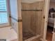 Bathroom with separate tub and tiled shower with a glass door and plantation shutters at 107 Heatherwood Trce, Acworth, GA 30101