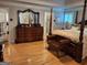 Bedroom with hardwood floors, a four poster bed, shuttered windows and traditional furniture at 107 Heatherwood Trce, Acworth, GA 30101