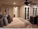 Cozy bedroom featuring a comfortable bed, ceiling fan, and glass paneled doors at 107 Heatherwood Trce, Acworth, GA 30101