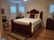Elegant bedroom with a wooden bed frame, shuttered windows, and hardwood floors at 107 Heatherwood Trce, Acworth, GA 30101