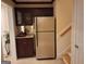 Lower level kitchenette has bar and small refrigerator adjacent to the downstairs staircase at 107 Heatherwood Trce, Acworth, GA 30101