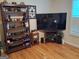 Bright living room featuring hardwood floors, a bookshelf, and a large television at 107 Heatherwood Trce, Acworth, GA 30101