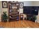 Bright living room featuring hardwood floors, a bookshelf, and a large television at 107 Heatherwood Trce, Acworth, GA 30101