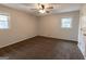 Cozy bedroom with plush brown carpet, modern ceiling fan, and natural light from two large windows at 203 Greensprings Dr, Palmetto, GA 30268