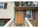 Inviting entrance features a vibrant orange door, complemented by a white railing and classic shutters at 203 Greensprings Dr, Palmetto, GA 30268