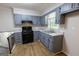 Updated kitchen showcasing blue cabinetry, gas range, stainless steel sink, and ample counter space at 203 Greensprings Dr, Palmetto, GA 30268