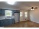Well-lit kitchen boasts modern blue cabinetry, stainless steel sink, and convenient access to the backyard at 203 Greensprings Dr, Palmetto, GA 30268