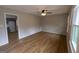 Bright living room featuring hardwood floors, a modern ceiling fan, and ample natural light from large windows at 203 Greensprings Dr, Palmetto, GA 30268